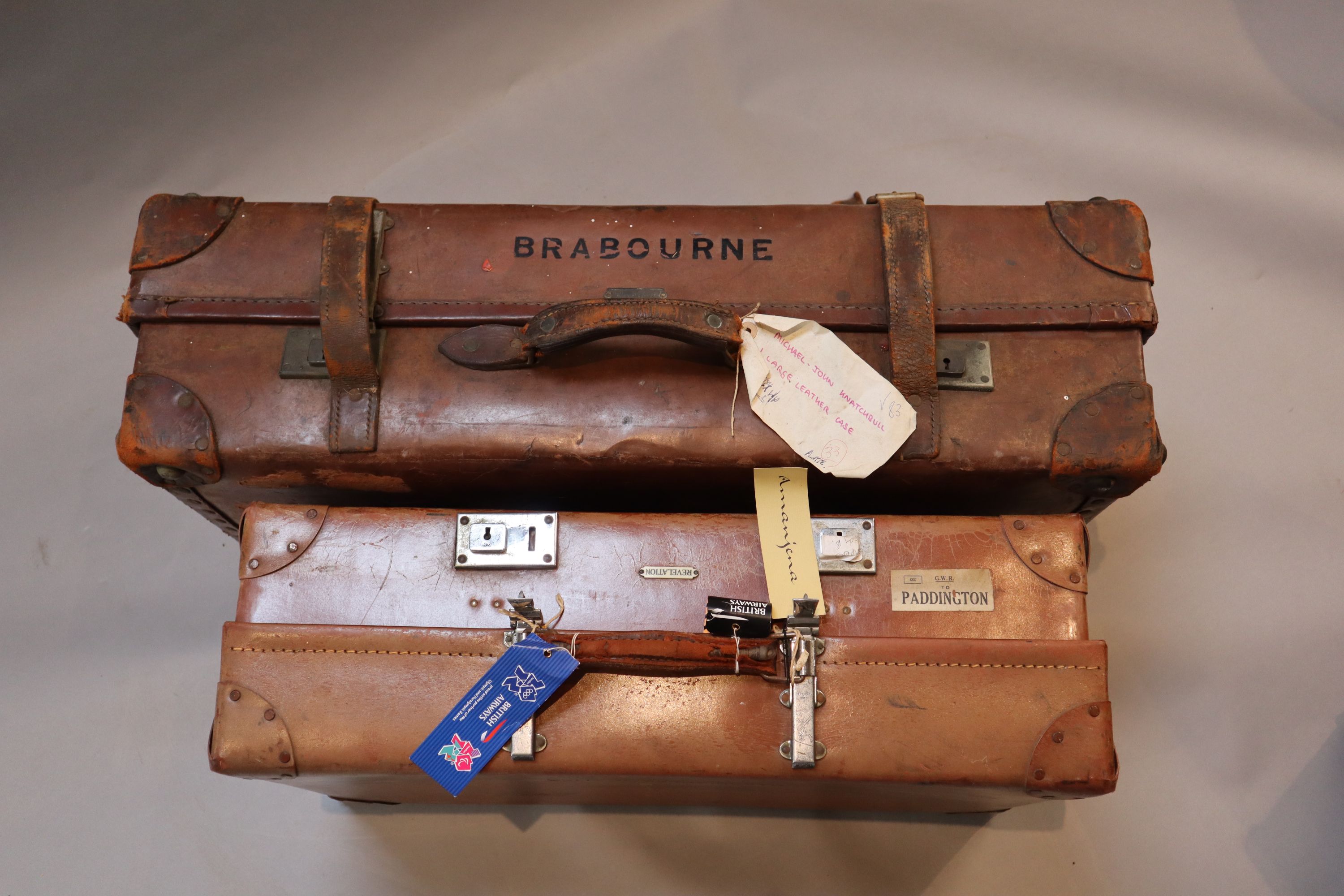 A group of three tan leather suitcases, one inscribed Brabourne, another Marchioness of Sligo